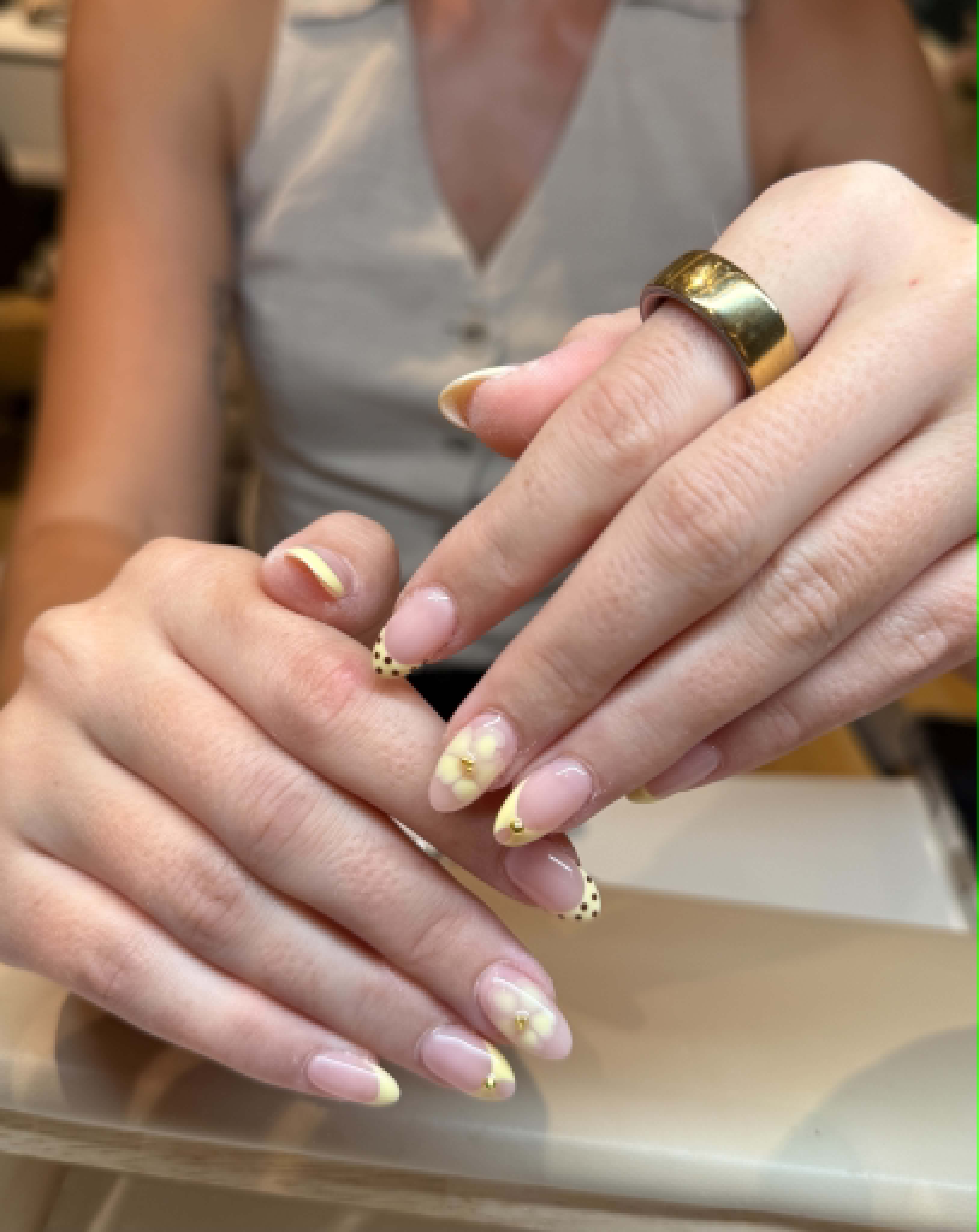 Yellow french nails with floral art and gold charm — Caitlyn Nails